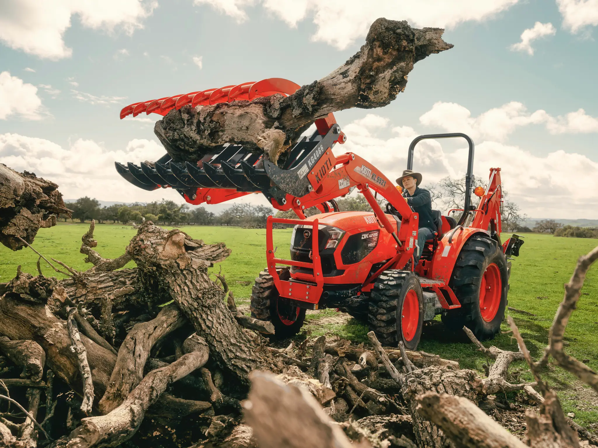 Kioti tractor loader moving branches
